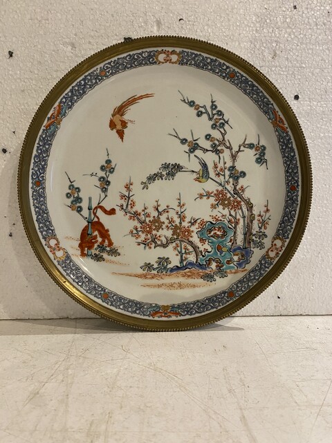 plats en porcelaine polychrome cerclage en laiton ciselé . XX siècle .